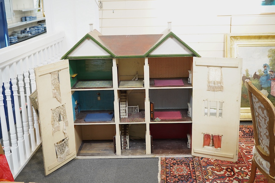 A large early 20th century double fronted wooden doll’s house, with two opening sections at the front and six internal rooms and stairwell, 120cm high, 112cm wide, 42cm deep. Condition - poor to fair